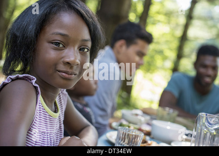 Ein junges Mädchen und Erwachsenen am Tisch sitzen Stockfoto