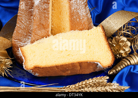 Weihnachten-Komposition mit Pandoro den goldenen Kuchen von Verona über einen blauen Hintergrund und goldenen Verzierungen. Stockfoto