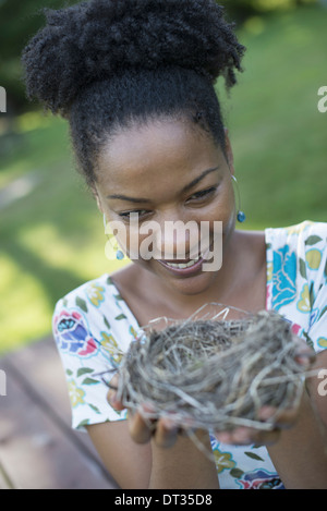 Eine Frau hält ein Vogelnest in ihren Händen Stockfoto