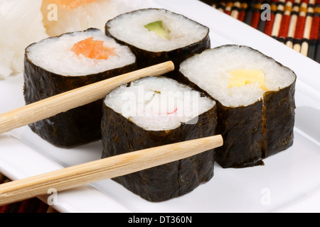 Nahaufnahme von Sushi auf einem weißen Tablett und hölzerne Stäbchen. Selektiven Fokus. Stockfoto