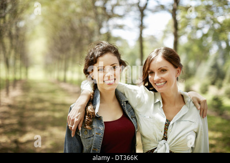 Zwei Mädchen Freunde lächelnd mit ihre Arme umeinander Stockfoto