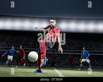 Fußball-Spieler treten Ball auf Feld Stockfoto