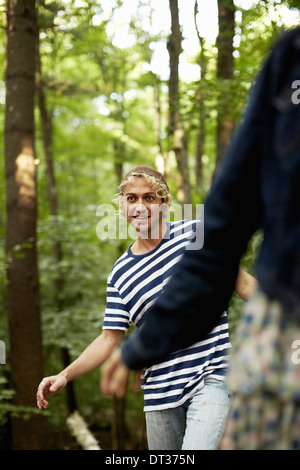 Zwei Menschen, die zu Fuß entlang einem gefallenen Baumstamm Stockfoto