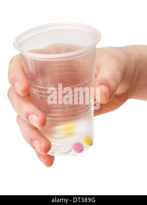 Plastikbecher mit Teil der Tabletten in der Hand isoliert auf weißem Hintergrund Stockfoto