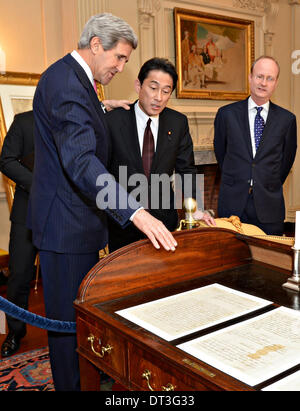 US-Außenminister John Kerry zeigt japanischen Außenminister Fumio Kishida den Schreibtisch, wo Ende des revolutionären Krieges 1783 Vertrag von Paris unterzeichnet wurde, in der John Quincy Adams Zustand Salon an das Department of State 7. Februar 2014 in Washington, DC. Stockfoto