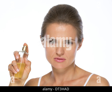 Junge Frau zeigt Parfüm-Flasche Stockfoto