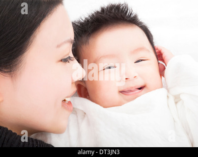 glückliche asiatische Mutter und Tochter oder Sohn lächelnd zusammen auf weiß Stockfoto