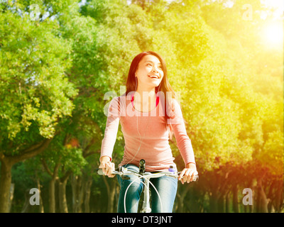 Ziemlich junge Asiatin Reiten Fahrrad im park Stockfoto