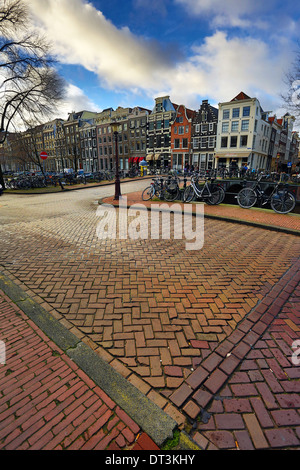 Straßenszene mit Fahrrädern auf einer Brücke über einen Kanal in Herengracht in Amsterdam, Holland Stockfoto