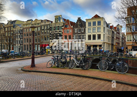 Straßenszene mit Fahrrädern auf einer Brücke über einen Kanal in Herengracht in Amsterdam, Holland Stockfoto