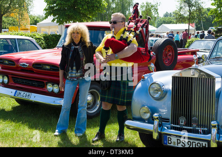 Piper spielt die Great Highland Bagpipe in der Nähe der Auto Rolls-Royce Silver Cloud Stockfoto