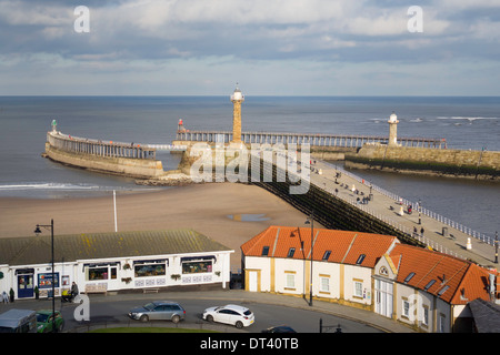 Menschen genießen den Sonnenschein zu Fuß auf Whitby West Pier Stockfoto