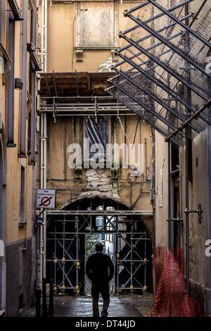 8. Februar 2014 - l ' Aquila, Abruzzo, Italien - geht ein Mann in l ' Aquila, Italien, am 8. Februar 2014. Vier Jahre nach dem Erdbeben vom 6. April 2009, L'Aquila Altstadt ist noch aufgegeben, der Prozess des Wiederaufbaus ist langsam außerhalb der Geschäftsräume und Kirchen und Denkmäler der Stadt sind noch mit Baugerüst bedeckt. (Kredit-Bild: © Manuel Romano/NurPhoto/ZUMAPRESS.com) Stockfoto