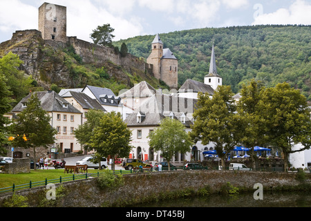 Blick auf Esch-sur-Sûre, Luxemburg, Europa an einem bewölkten Tag, wie man ihn im Sommer vom Flussufer aus sieht, mit Ruine einer alten Burg auf dem Hügel Stockfoto