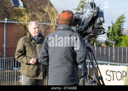 Burrowbridge, Somerset, UK. 8. Februar 2014. Konservative MP Herr Ian Liddell-Grainger interviewt von BBC News am 8. Februar 2014 stand auf der Brücke über den Fluß Parrett auf die A361 am Burrowbridge, Somerset. Wegen starker Regenfälle haben die Flüsse Parrett und Ton ihre Banken platzen, Überschwemmungen in der Nähe von Ackerland und verlassen unter Wasser Häuser. Nach besuchen von Herrn Chris Smith und David Cameron gestern eine schwere Wasseralarm bleibt und einige Bewohner zu evakuieren gesagt worden. Die Somerset Niveaus haben erlebt den schlimmsten Überschwemmungen in der lebendigen Geschichte. Bildnachweis: Nick Kabel/Alamy Live Stockfoto