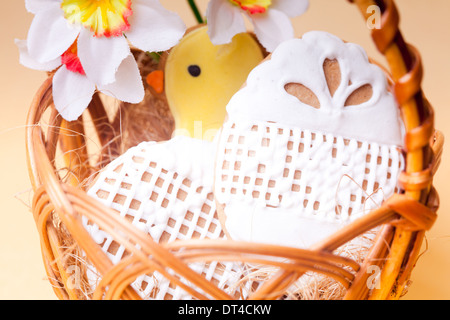 Osterkekse im Korb auf gelbem Hintergrund. Ostern Dekoration Stockfoto