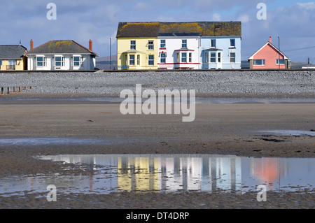 Unterkünfte am Meer hinter dem Deich am Borth in der Nähe von Aberystwyth, Ceredigion, Wales, UK zeigt den Strand bei Ebbe. Stockfoto