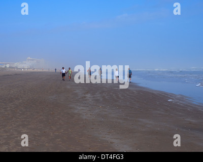 Touristen Fuß am Strand an einem nebligen Morgen im Winter in South Padre Island, Texas Stockfoto