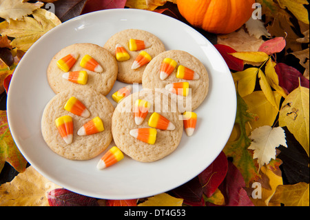 Teller mit Süßigkeiten Mais Keksen mit bunten Herbst Blätter Stockfoto