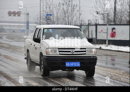 Der Provinz Hunan Changsha, China. 9. Februar 2014. Ein Auto läuft auf einer verschneiten Straße in der Innenstadt von Changsha, der Hauptstadt der Provinz Zentral-China Hunan, 9. Februar 2014. Changsha sah die ersten Schneefälle in den Lunar Jahr des Pferdes am Sonntag. Bildnachweis: Lange Hongtao/Xinhua/Alamy Live-Nachrichten Stockfoto