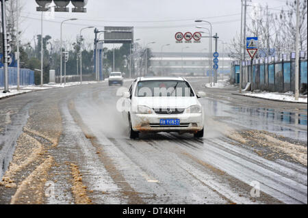 Der Provinz Hunan Changsha, China. 9. Februar 2014. Fahrzeuge laufen auf einer verschneiten Straße in der Innenstadt von Changsha, der Hauptstadt der Provinz Zentral-China Hunan, 9. Februar 2014. Changsha sah die ersten Schneefälle in den Lunar Jahr des Pferdes am Sonntag. Bildnachweis: Lange Hongtao/Xinhua/Alamy Live-Nachrichten Stockfoto