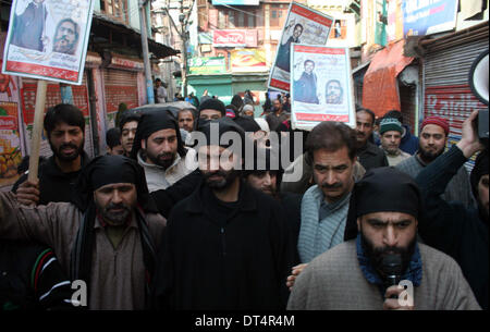 Srinagar, indische verabreicht Kaschmir. 9. Februar 2014: Yasin Malik Führer von Jammu und Kaschmir Liberation Front, eine Widerstandsgruppe Widerstand pro Unabhängigkeit halten Plakate als, sie schreien Parolen während einer Protestaktion am ersten Jahrestag von Mohammad Afzal Guru in Srinagar, der Hauptstadt des indischen Kashmir,India.Curfew verabreicht Sommer inmitten komplette Abschaltung auf den ersten Todestag von Mohammad Afzal Guru gehängt und von der indischen Regierung in Indiens Tihar-Gefängnis für seine angebliche Herrschaft im indischen begraben wurde auferlegt wurde Parlament-Angriff der 13. Dezember 2001. (Sofi Suhail / Alamy Live Stockfoto