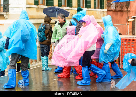 Venedig, Italien. Menschen in nassem Wetter Kleidung, Regenponchos und Gummistiefel, auf Brücke im Regen stehen. Stockfoto