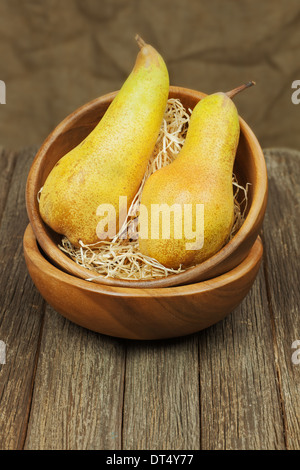 Reife Birnen in Schüssel auf hölzernen Hintergrund. Closeup. Stockfoto