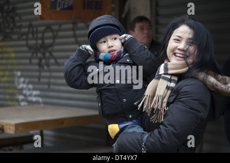 Mutter und Sohn hält seine Ohren während der chinesischen Neujahr Feuerwerk Zeremonie in Chinatown, NYC. 2014, Jahr des Pferdes. Stockfoto