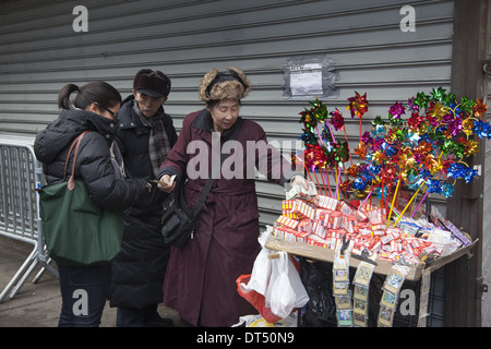 Ältere Frau Verkauf von Artikeln für Chinese New Year auf der Straße in Chinatown in New York City. Stockfoto