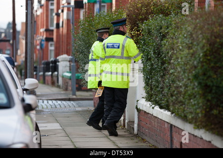 Gemeinschaft unterstützen Offiziere mit einem Nummernschild in Anfragen, nachdem eine Reihe von Autos in Liverpool verwüstet wurden. Stockfoto