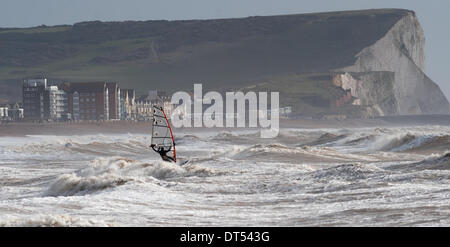 Ein Windsurfer kämpfen gegen die Wellen Gezeiten-Mühlen Strand Newhaven heute als Stürme weiterhin der South Coast of Britain Teig. Seaford Kopf Klippen in Ferne zu sehen Stockfoto