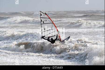 Ein Windsurfer kämpfen gegen die Wellen Gezeiten-Mühlen Strand Newhaven heute weiterhin als Stürme der South Coast of Britain Teig Stockfoto