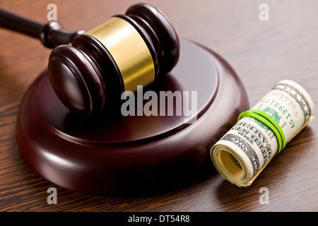 Hammer mit Pack von Dollar auf hölzernen Hintergrund zu beurteilen Stockfoto