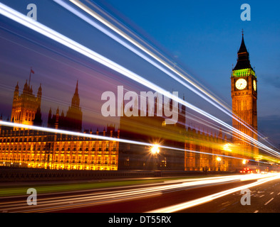 Big Ben Clock Tower Houses of Parliament in der Nacht mit verschwommenen Lichtern der vorbeifahrenden roten Londoner Bus im Vordergrund London England UK Stockfoto