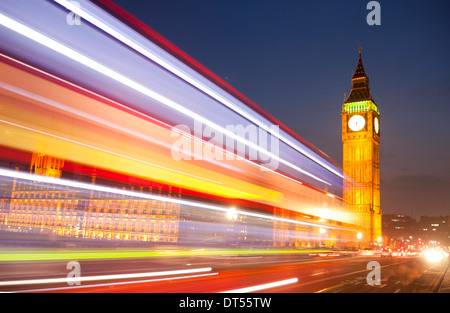 Big Ben Clock Tower Houses of Parliament in der Nacht mit verschwommenen Lichtern der vorbeifahrenden roten Londoner Bus im Vordergrund London England UK Stockfoto