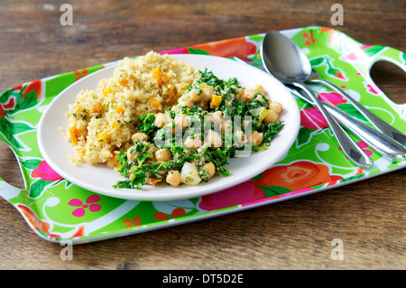 Eine herzhafte und sättigende Mahlzeit mit Grünkohl, Cashew und Kichererbsen, serviert mit Konfetti Couscous. Stockfoto