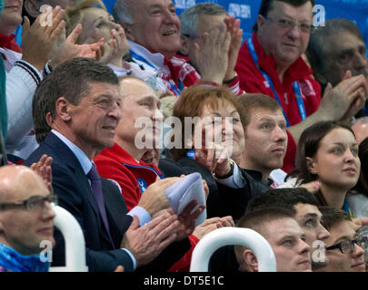 Sotschi, Russland. 9. Februar 2014. Der russische Präsident Vladimir Putin weist er Uhren Yulia Lipnitskaya führen Sie in der Kür der Damen im Eisberg Skating Palace während der Olympischen Winterspiele 2014 in Sotschi. Bildnachweis: Paul Kitagaki Jr./ZUMAPRESS.com/Alamy Live-Nachrichten Stockfoto