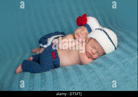 Jungen und Mädchen zwei neugeborene Babys tragen gehäkelte Matrosen-Outfits. Stockfoto