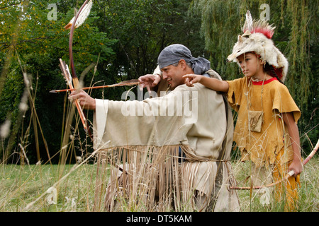 Native American Indian Mann mit einem Bogen und einem Pfeil Jagd mit einem jungen Stockfoto