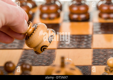 Mann spielt Schach und macht den Umzug mit Schach Schachfigur im Fokus Stockfoto