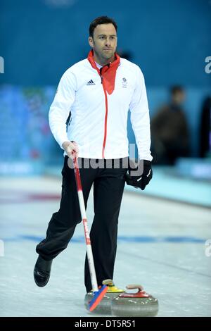 Sotschi, Russland. 10. Februar 2014. David Murdoch (GBR) aufräumt die Eisbahn am Ende des Spiels. Mens Curling - Eisbergs Arena - Olympiapark - Foto: Obligatorische Sturmpartner: Garry Bowden/SIPPA/Pinnacle - Credit: Sport In Bilder/Alamy Live News Stockfoto