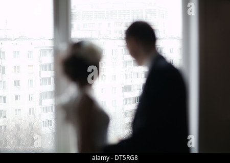 Brautpaar schaut aus dem Fenster Stockfoto