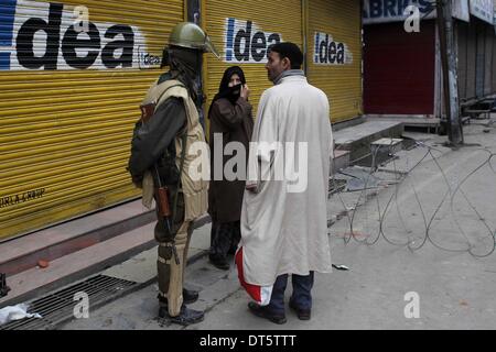 Srinagar, Kaschmir Indien kontrollierten. 10. Februar 2014. Eine indische paramilitärischer Soldat hält zwei Fußgänger während Einschränkung in Srinagar, Sommer in der Hauptstadt von Indien kontrollierten Kaschmir, 10. Februar 2014. Leben in mehrheitlich muslimischen Gebieten von Indien kontrollierten Kaschmir blieb Montag betroffenen für den zweiten Tag aufgrund von Einschränkungen durch Behörden und die Abschaltung von separatistischen Gruppen genannt. © Javed Dar/Xinhua/Alamy Live-Nachrichten Stockfoto