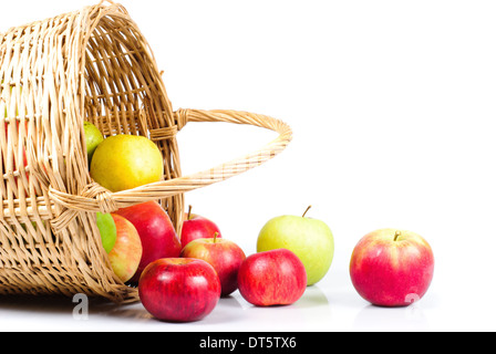 Korb und Äpfel sind auf weißem Hintergrund Streuung. Symbol des Herbstes Stockfoto