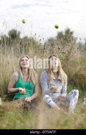 Zwei verspielte Mädchen jonglieren im freien Stockfoto