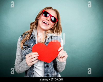 Closeup Portrait der fröhliche junge weibliche Beteiligung an Händen roten herzförmigen romantische Grußkarte, Valentinstag, teenage love Stockfoto