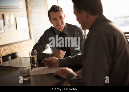 Geschäftspartnern unterzeichnet Vertrag in der Weinbar Stockfoto