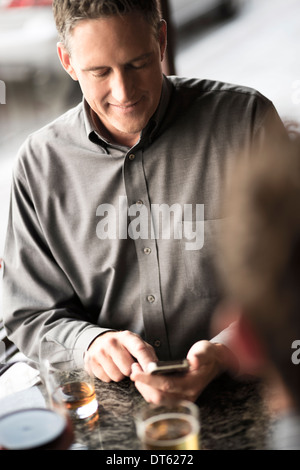 Geschäftsmann mit Handy in der Weinbar Stockfoto