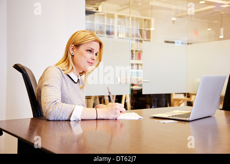 Junge Frau am Tisch arbeiten Stockfoto